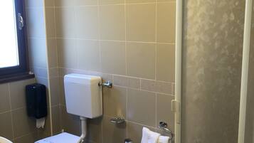 A bathroom with a toilet, bidet, and sink.