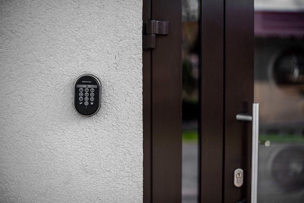 A keypad door lock on a textured wall.