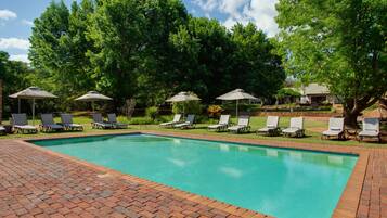 Alberca al aire libre y camastros