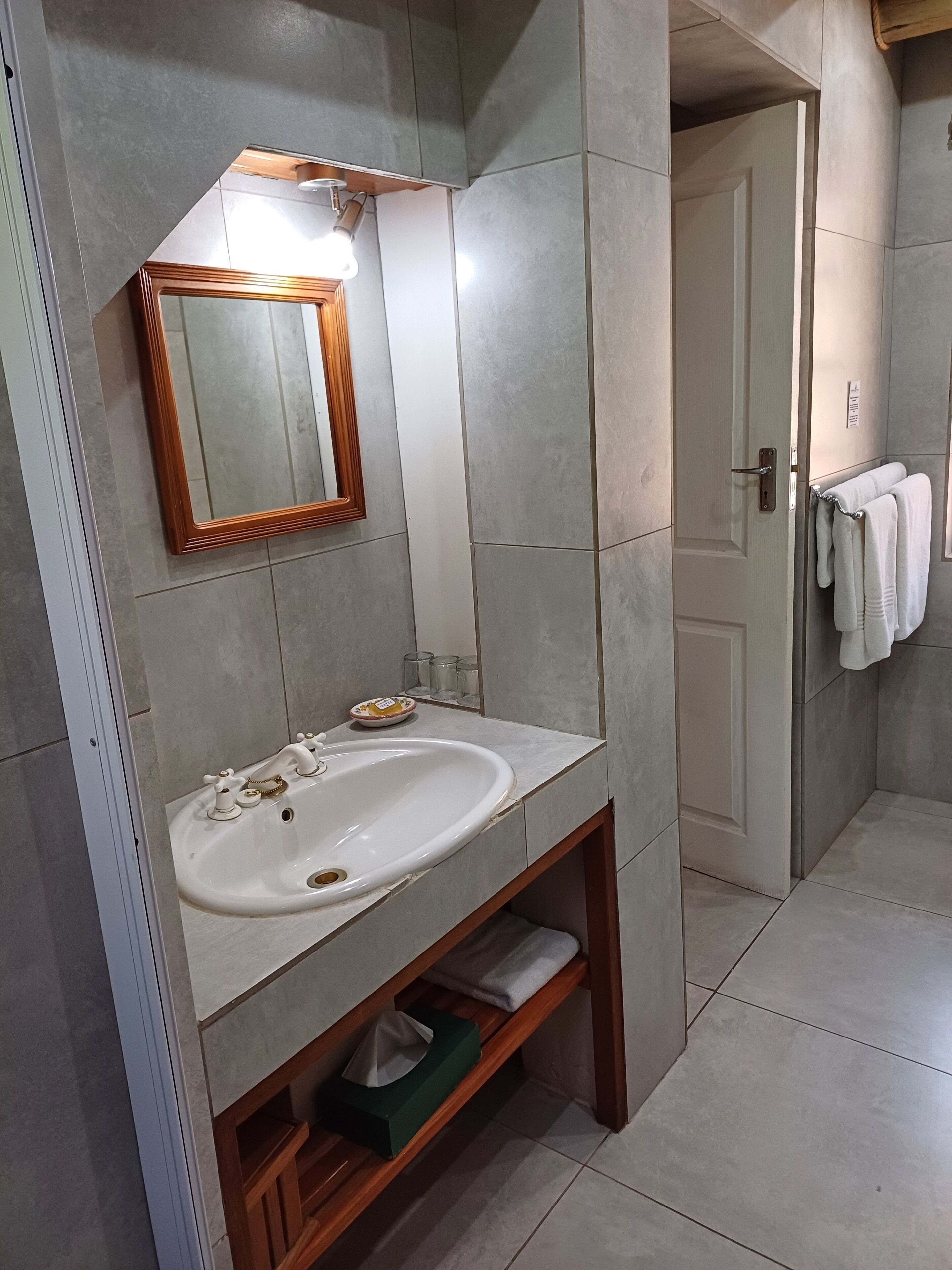Ein Badezimmer mit Waschbecken, Spiegel und Handtuchhalter.