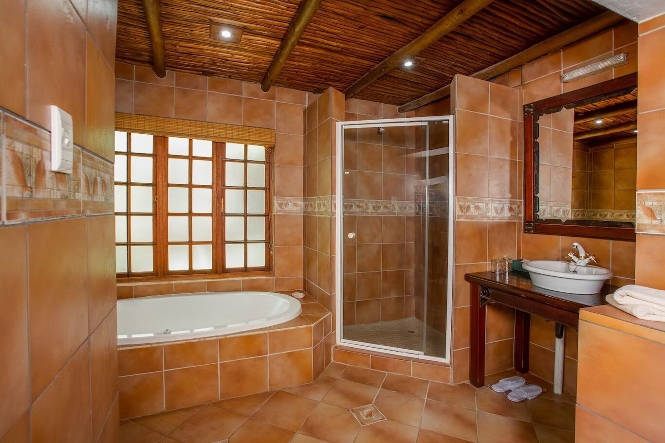 Un baño con bañera, cabina de ducha y tocador con lavamanos.