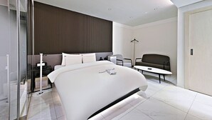 A modern hotel room with a large bed, a desk, and a seating area. - Rendezvous HOTEL (Hanam)