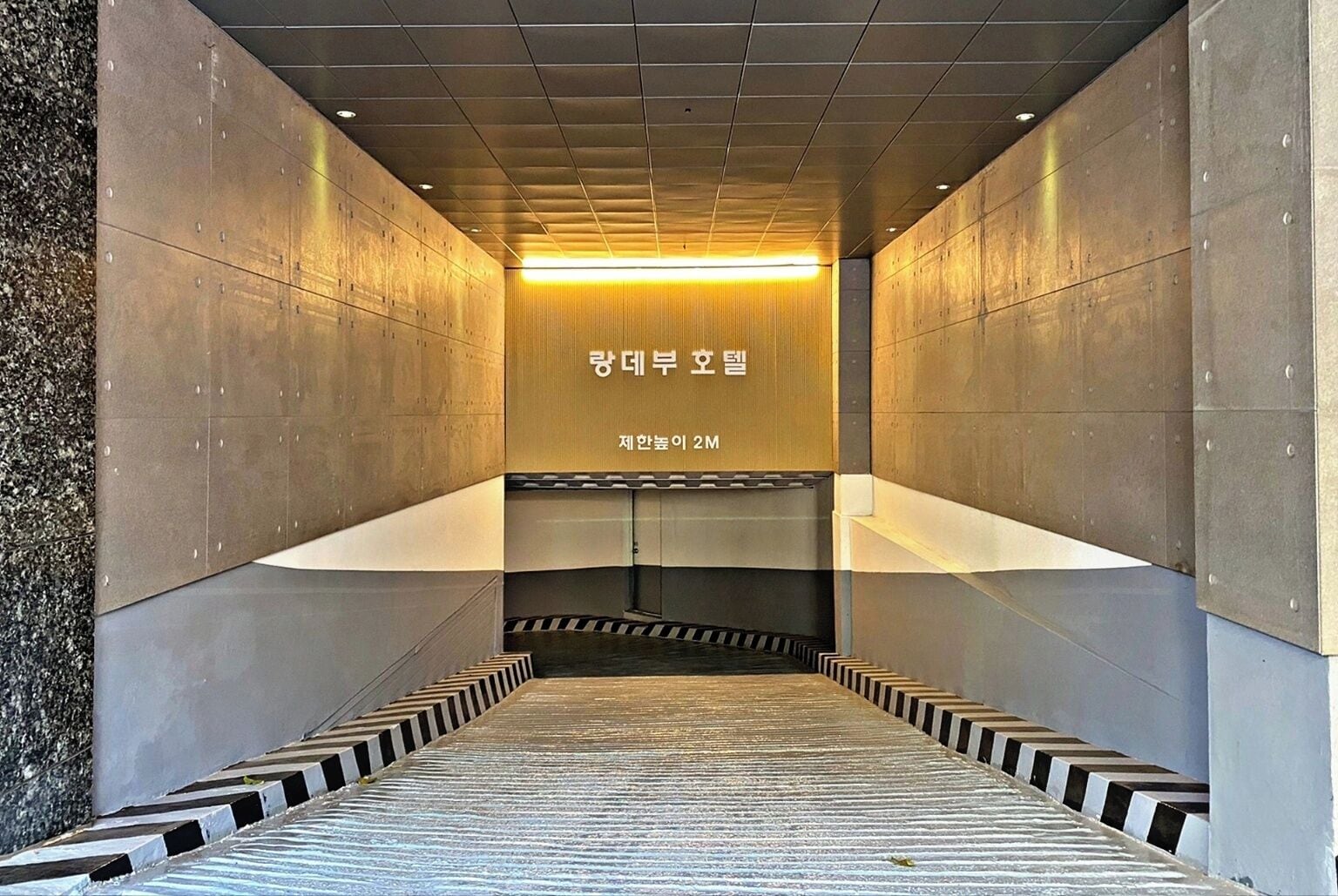 A modern elevator shaft with metallic walls and a patterned floor.