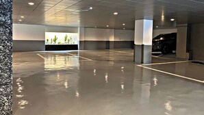 A spacious parking garage with a polished concrete floor and a modern design. - Rendezvous HOTEL (Hanam)