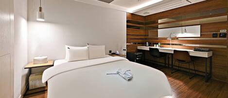 Une chambre d’hôtel moderne avec un grand lit, un bureau et un miroir.