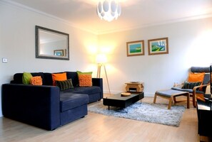 Apartemen | Area keluarga | TV layar datar, pemutar DVD, dan buku