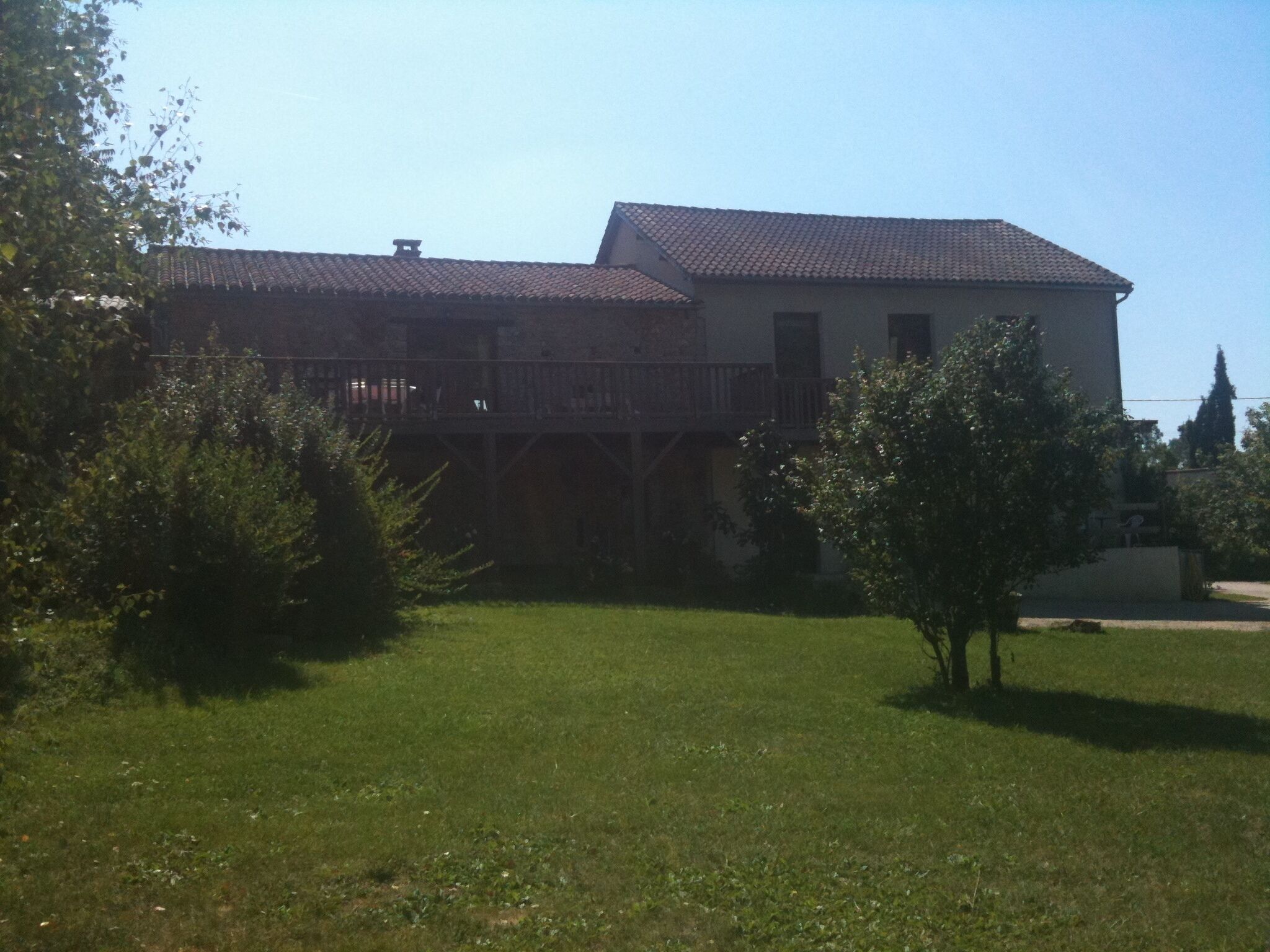 A two-story house with a balcony and a fenced yard.