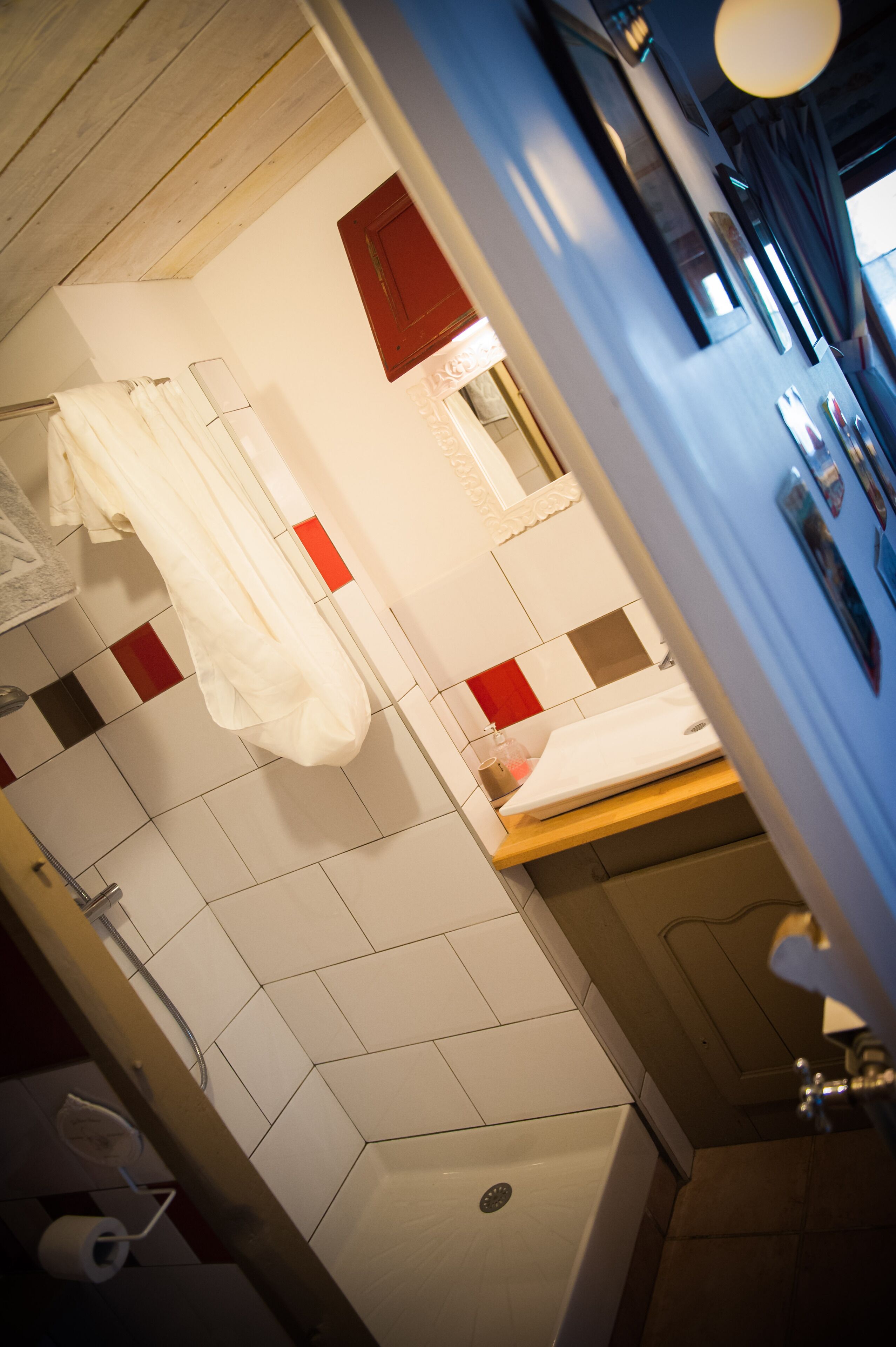 A bathroom with a shower, a sink, and a mirror.