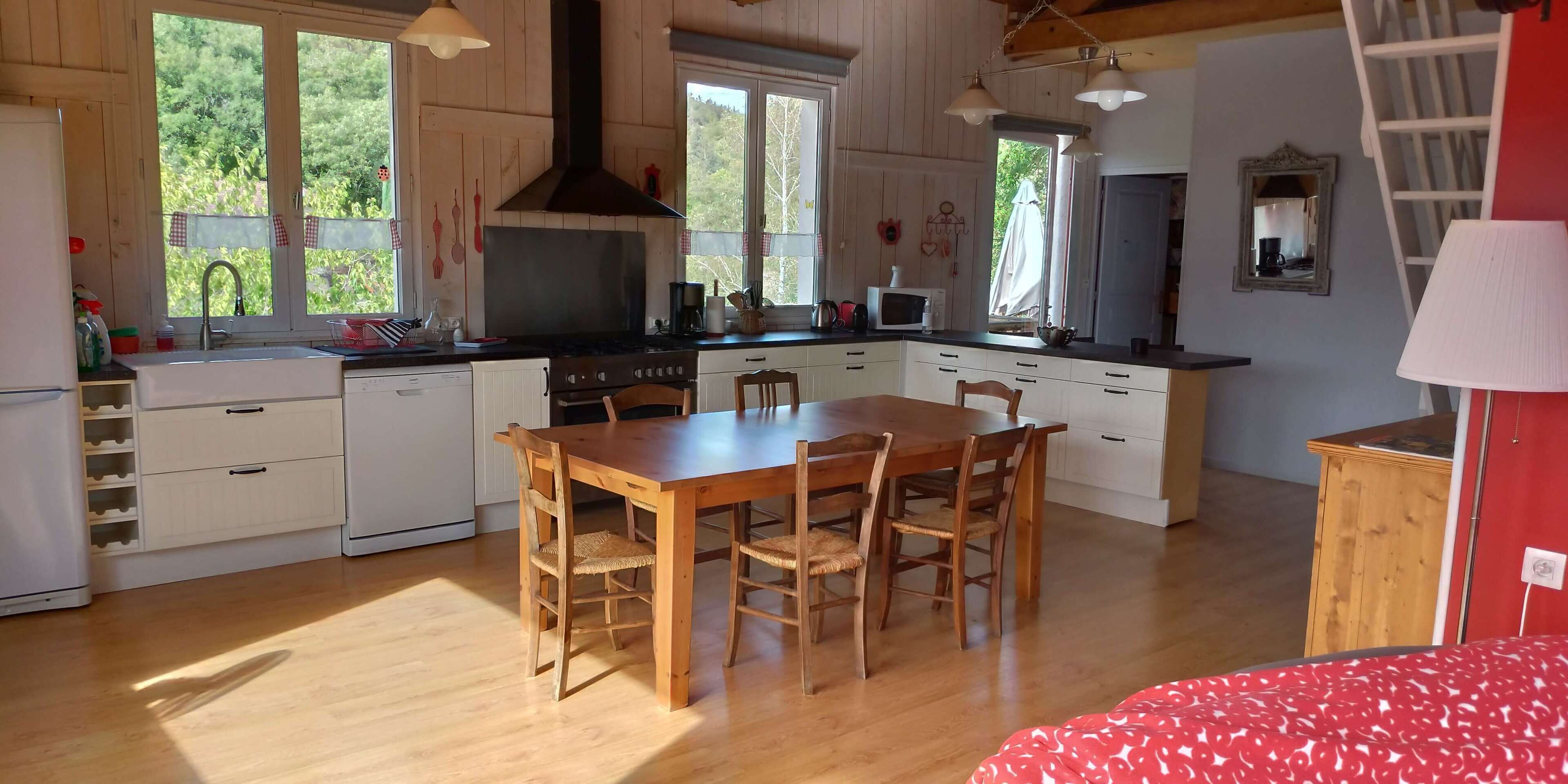 A spacious kitchen with wooden cabinets, a central island, and a dining area with chairs.