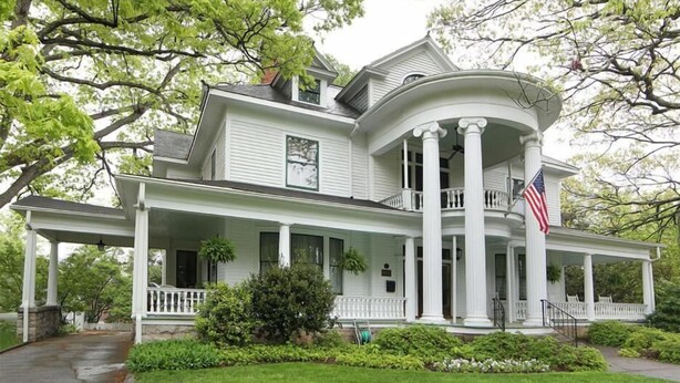 A large, two-story house with a wrap-around porch and a central tower. - Double Oaks Bed and Breakfast (Greensboro)