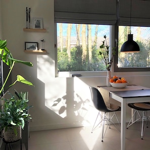 Enjoy cooking in this well-equipped kitchen with a large window, white countertop, and dining table.