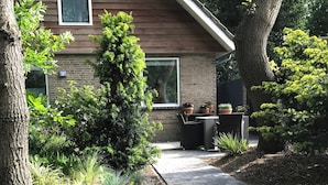 A garden with a paved walkway, potted plants, and a brick wall. - Studio OAK, modern 2-p-residence with private garden, near village, sea and dune (Bergen)