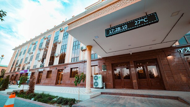 A hotel with a digital sign displaying the time and temperature. -  Reikartz Kokand (Kokand)
