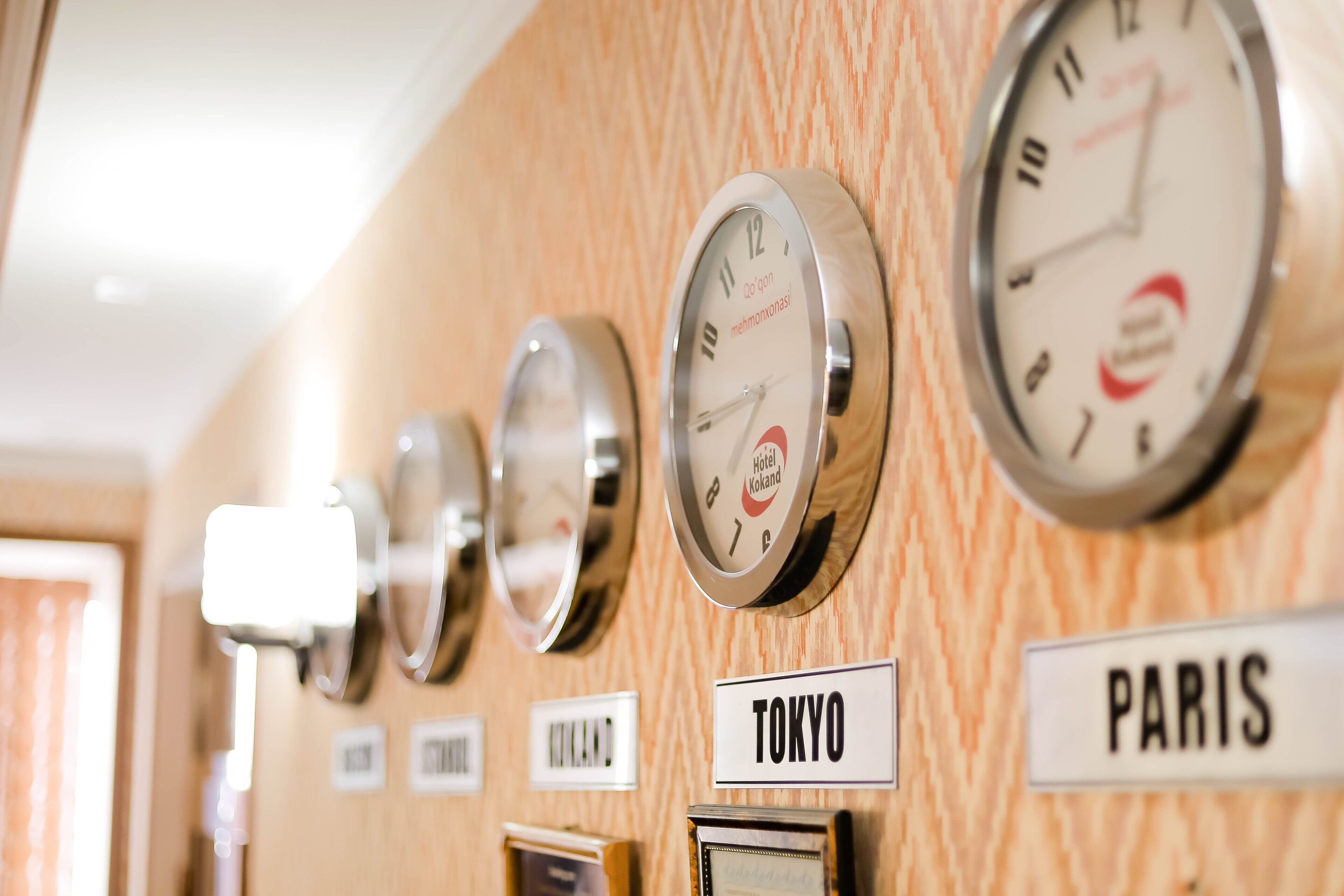 Uhren an einer Wand mit Schildern für Tokio und Paris.