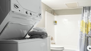 A laundry area with a washing machine and dryer, a toilet, and a shower. - 30-Night Minimum Studio Near Main Street (St Charles)
