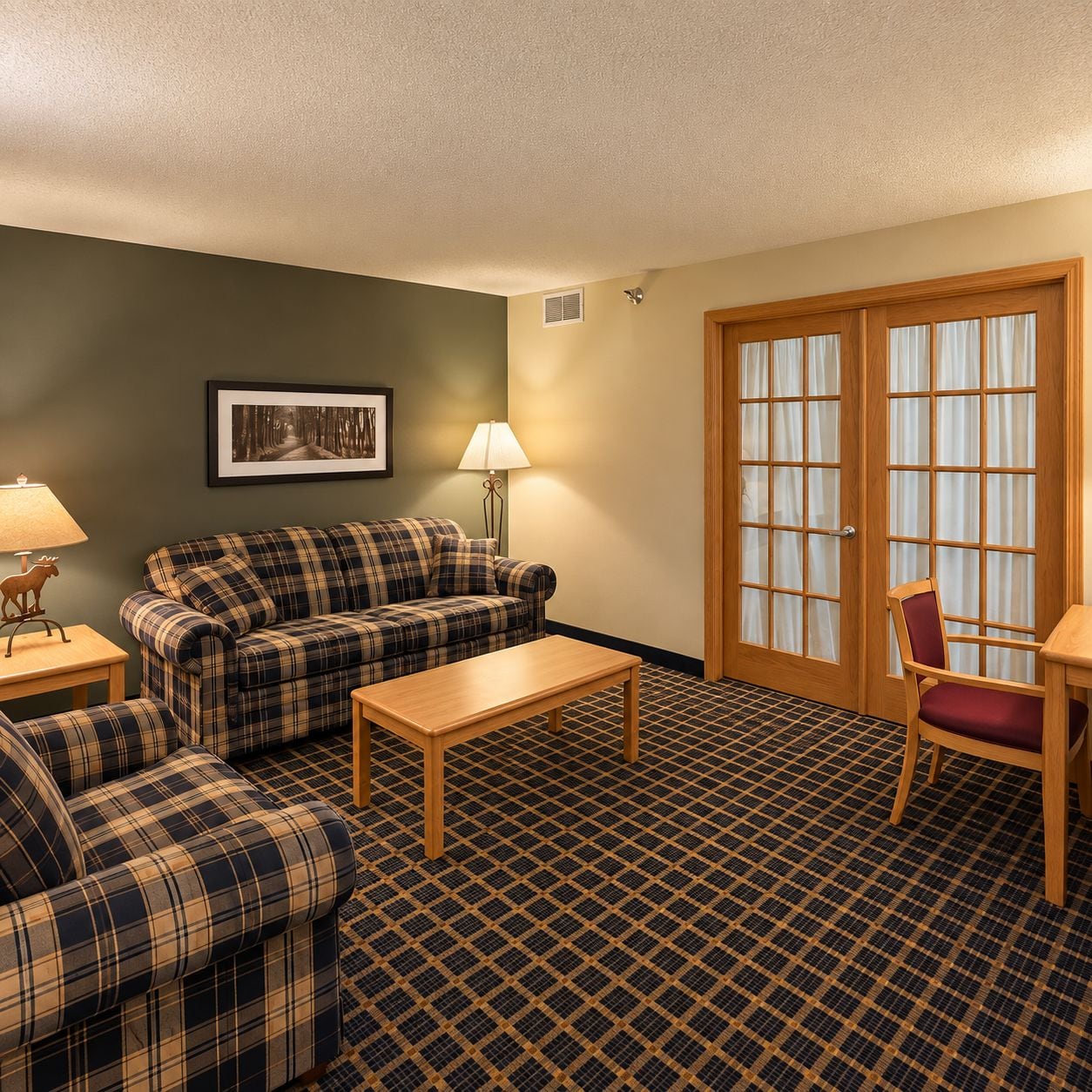 A room with a plaid sofa set, a wooden coffee table, a lamp, a chair, and a door with glass panels.