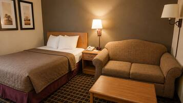 A hotel room with two beds, a sofa, a table, a lamp, and a telephone.