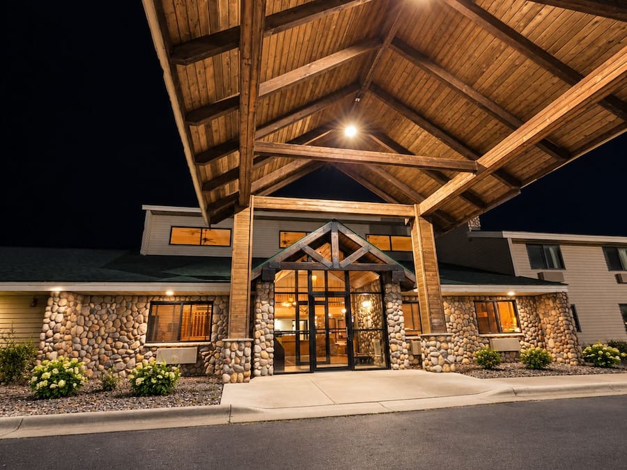 A building with a stone facade, a wooden overhang, and a well-lit entrance.