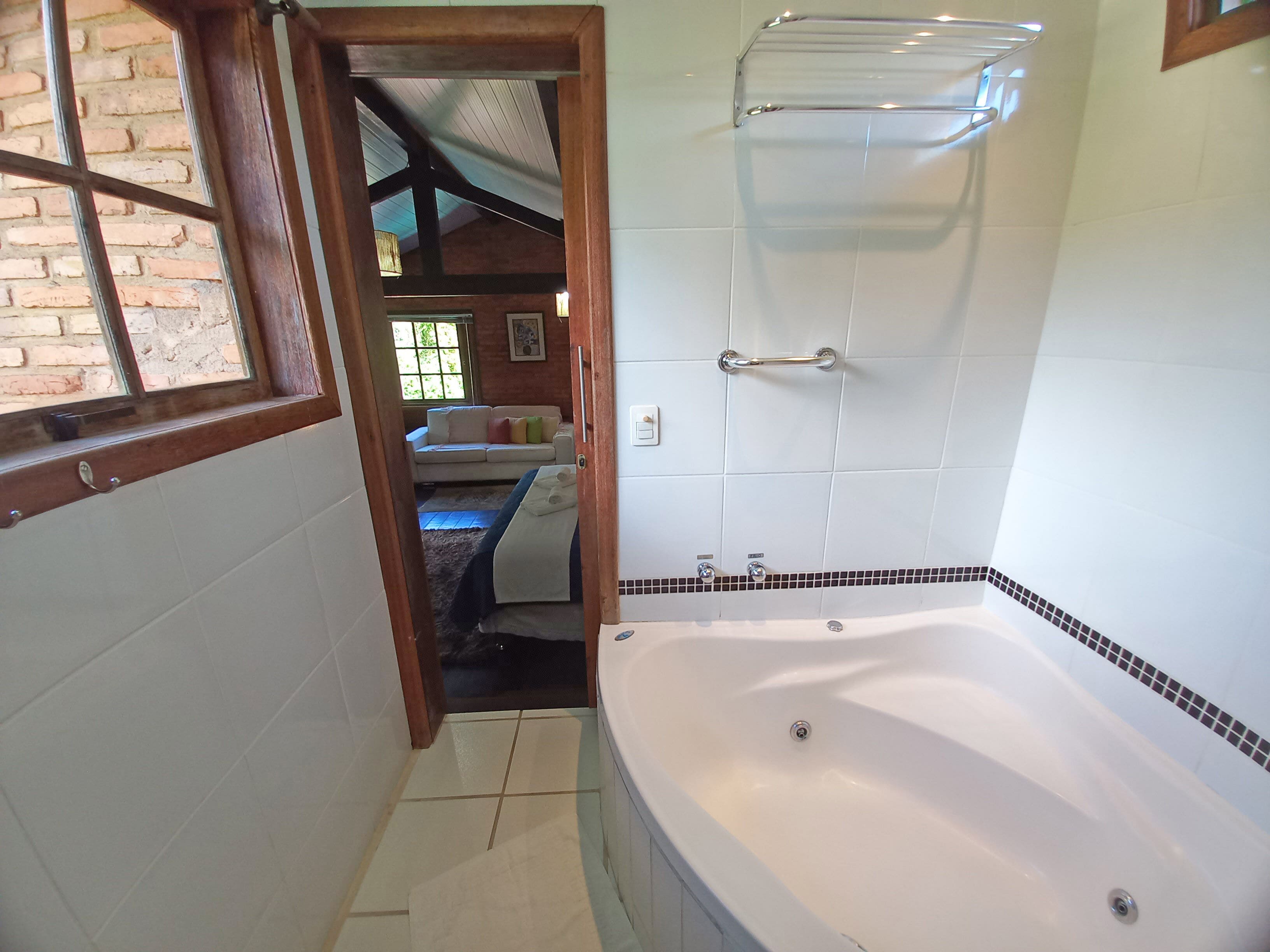A bathroom with a bathtub, a shower, and a window.
