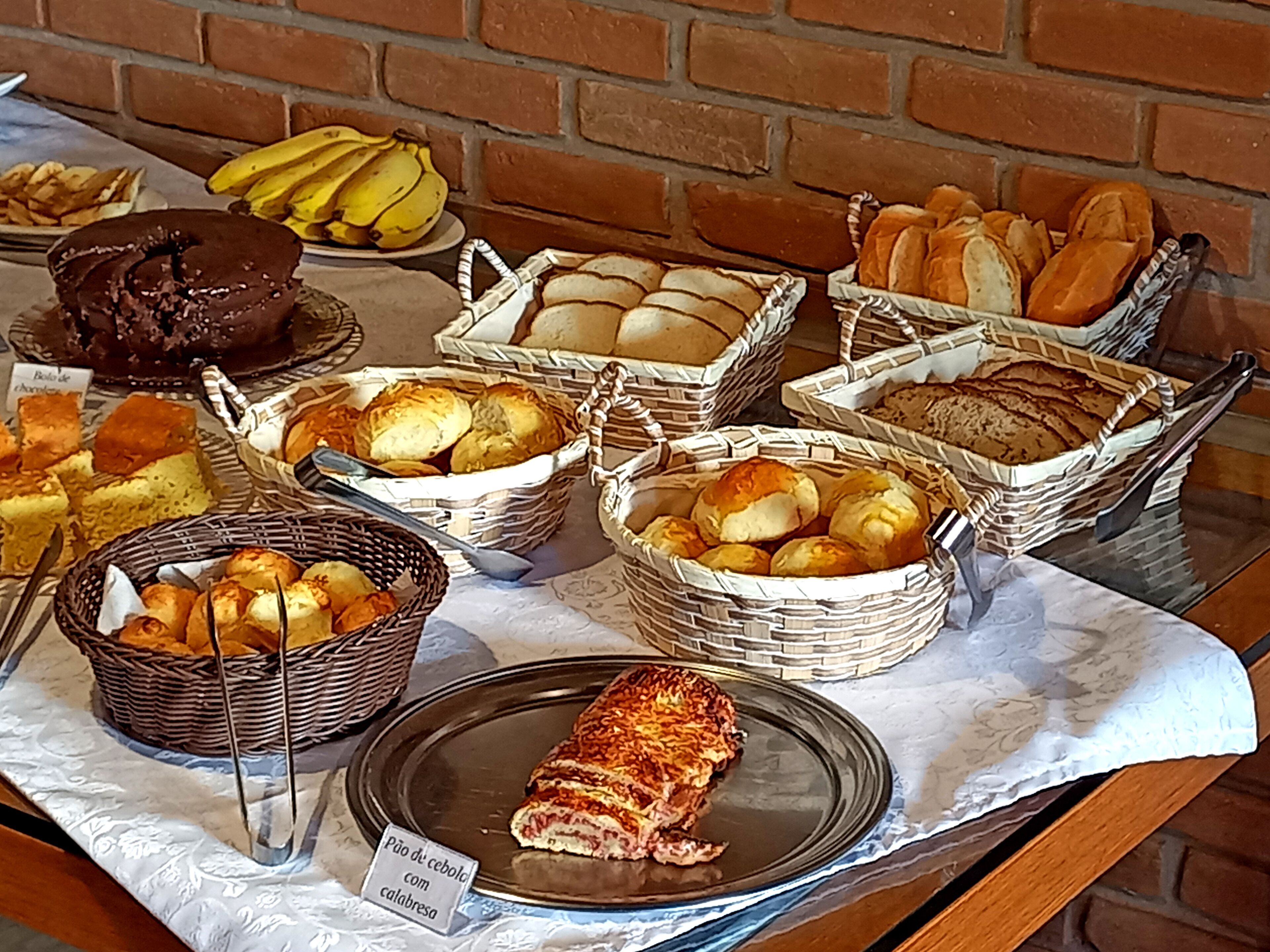 Un bufé con diversas opciones de panadería, incluyendo pan, pasteles y un pastel.