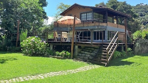 A two-story house with a balcony, surrounded by lush greenery. - Pousada Visconde de Mauá (Resende)