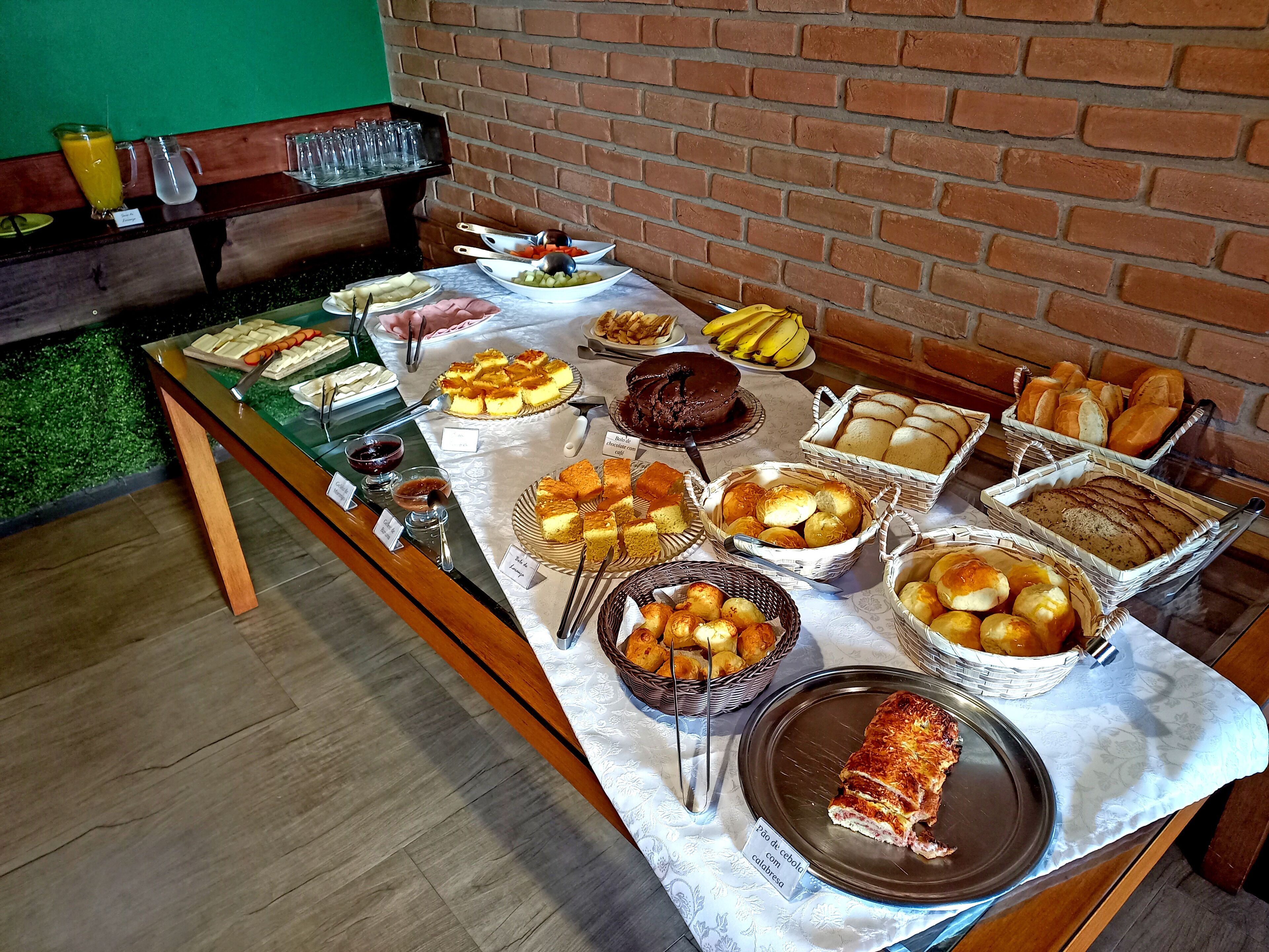 Una mesa de bufé con distintos alimentos y un pastel sobre un mantel.