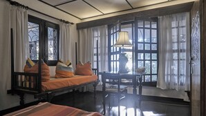 A room with a bed, a table, and a window with curtains. - The Icebear Guesthouse (Negombo)