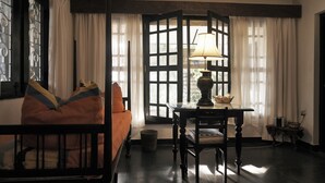 A room with a bed, a table with a lamp, and a window with curtains. - The Icebear Guesthouse (Negombo)