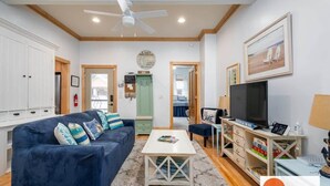 A living room with a sofa, coffee table, TV, and a ceiling fan. - Lake Life Getaway - Condo near downtown! (Douglas)