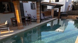 A clear swimming pool with steps leading into it, surrounded by lounge chairs and a patio area. - Casa Sigrunella++with infinity pool (12x4m)++ in Cala Llombards (Cala Llombards)