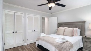 A bedroom with a bed, a ceiling fan, a nightstand, and a wardrobe. - Oxford Square! Amazing Location! (Oxford)