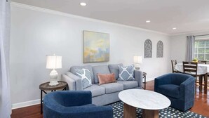 A living room with a grey sofa, two blue armchairs, a round coffee table, and a patterned rug. - Oxford Square! Amazing Location! (Oxford)