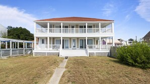 A two-story house with a covered porch and a front yard.