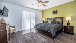 A bedroom with a bed, two bedside tables, a ceiling fan, a television, and a window with blinds. - Beautiful Villa With Private Pool, Orlando Villa 1488 (Davenport)