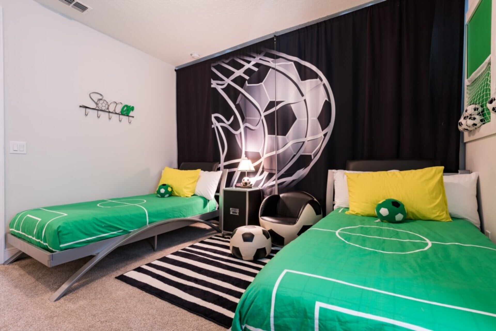 Een hotelkamer met twee bedden, een zwart-wit gestreept tapijt en een muur met een geometrisch ontwerp.