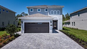 A modern two-story house with a garage, paved driveway, and well-maintained lawn. - Villa in Encore Resort at Reunion 2986 (Kissimmee)