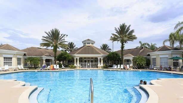 A large outdoor swimming pool with lounge chairs and palm trees. - Villa in Windsor Palms Resort 1217 (Kissimmee)
