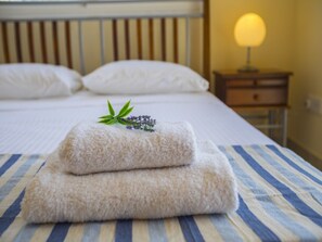 A neatly made bed with white pillows and a folded towel with a sprig of lavender on top. - Beautiful Villa With Private Pool, Protaras Villa 1010 (Paralimni)