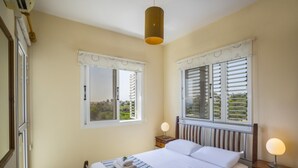 A bedroom with a bed, bedside tables, and two windows with shutters. - Beautiful Villa With Private Pool, Protaras Villa 1010 (Paralimni)