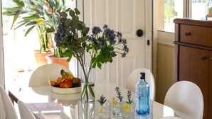 A dining table with a bowl of fruit, a vase with flowers, and several glasses with lemon slices. - Beautiful Villa With Private Pool, Protaras Villa 1010 (Paralimni)