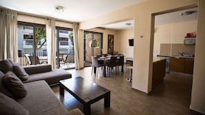 Una habitación de hotel moderna con zona de estar, comedor y kitchenette.