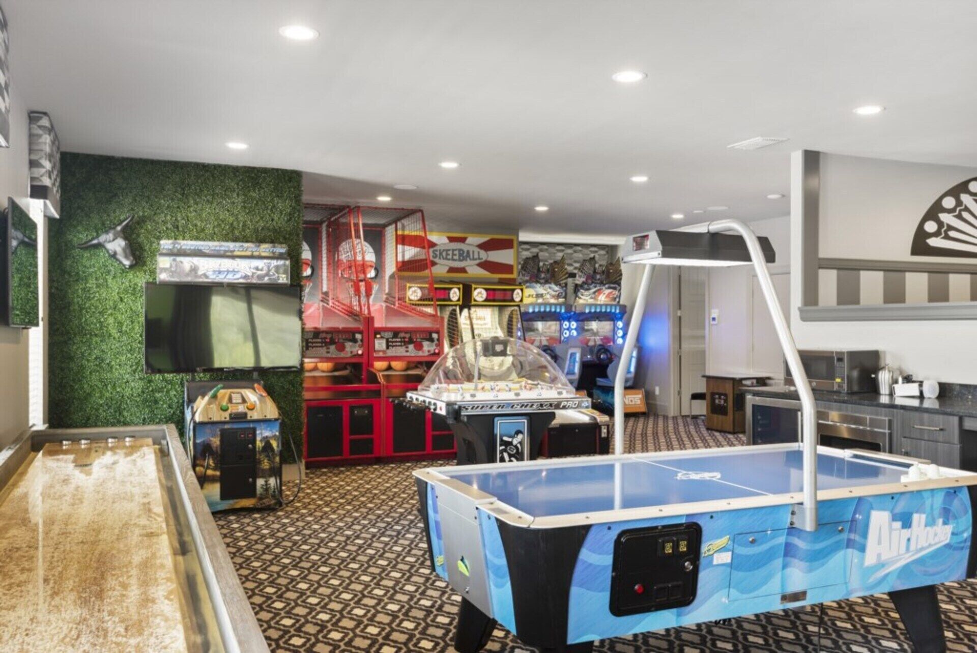 Une pièce équipée d’une table de billard, de jeux d’arcade et d’un téléviseur.