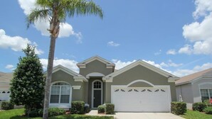 A single-story house with a front garage, a small front yard, and a palm tree. - Villa in Windsor Palms Resort 1260 (Kissimmee)