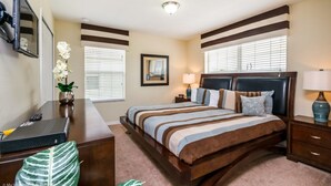 A bedroom with a large bed, a desk, a chair, and a lamp. - Townhome in Champions Gate Resort 2819 (Kissimmee)