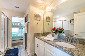 A bathroom with a granite countertop, a sink, a mirror, and a shower area. - Villa in Champions Gate Resort 2509 (Davenport)