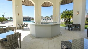 A covered outdoor area with a pool, seating, and a bar. - Private Resort Home 1131 (Davenport)