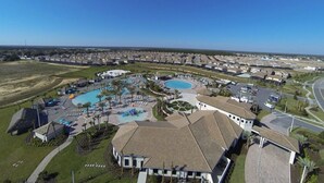 An aerial view of a residential area with a large swimming pool, multiple buildings, and a clear sky. - Private Resort Home 1131 (Davenport)
