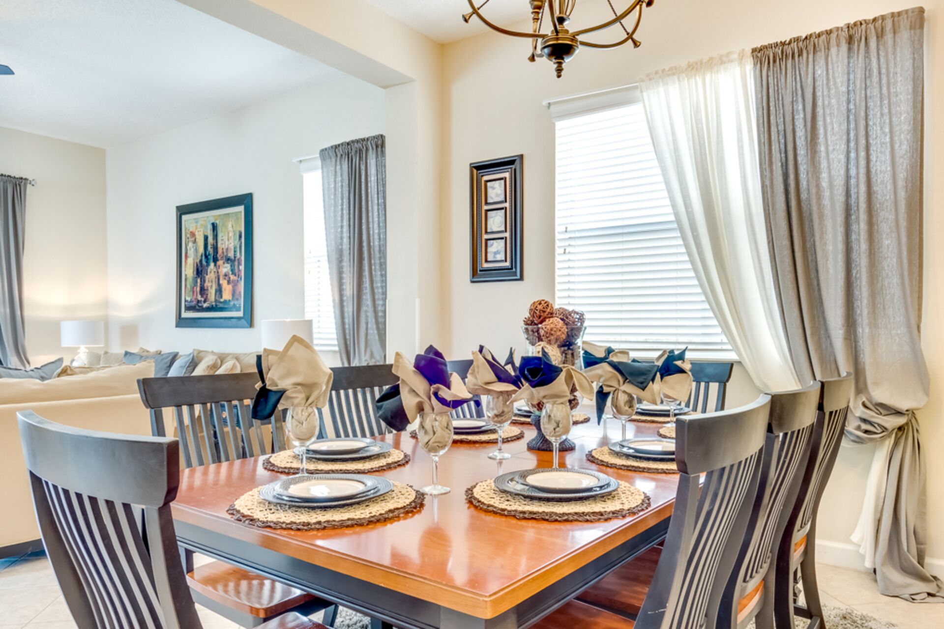 Comedor con una mesa de madera dispuesta para cuatro personas, rodeado de sillas.