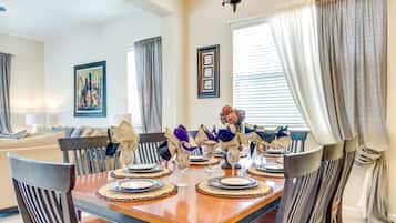 Comedor con una mesa de madera dispuesta para cuatro personas, rodeado de sillas.