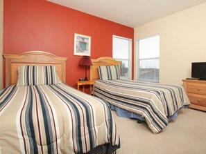 A hotel room with two beds, a red wall, a window, and a television. - Villa in Windsor Palms Resort 1433 (Kissimmee)